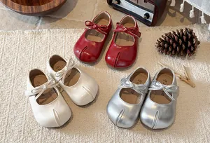 Detail view of girls' split-toe Mary Jane shoes with cute bows in red, white, and silver