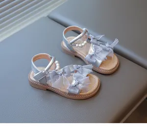 Detailed view of silver girls' princess sandals with tulle bows and pearl beads