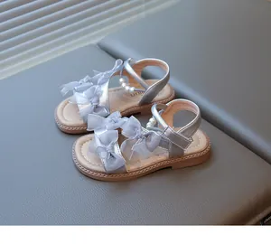 Detail view of silver girls princess sandals with elegant gauze bows and pearl accents