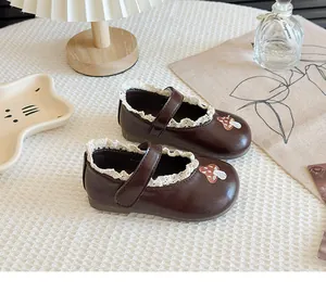 Brown girls' Mary Jane shoes with delicate lace trim and cute mushroom embroidery detail