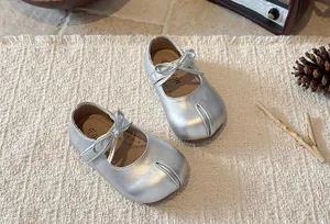 Detailed view of silver metallic girls' Mary Jane shoes with elegant bow detail.