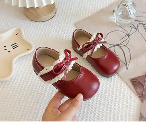 Detaillierte Ansicht roter Kleinkindschuhe für Mädchen mit Spitzenbesatz und Schleife