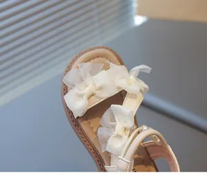 Detailed view of girls' princess sandals with delicate lace bows and pearl accents