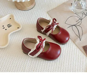 Detailansicht rote Mädchen-Mary-Jane-Schuhe mit Spitzenbesatz und süßer Schleifendekoration