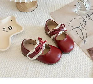 Detailansicht der roten Mädchen-Lederschuhe mit elegantem Spitzenbesatz und schöner Schleife.