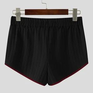 Rear view of black ribbed men's shorts with red contrast trim and elastic waistband