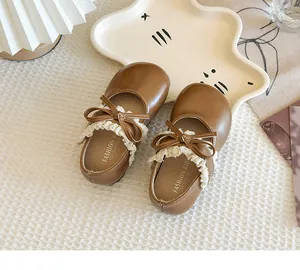Detailansicht brauner Kleinkindschuhe für Mädchen mit zarter Spitze und Schleife.