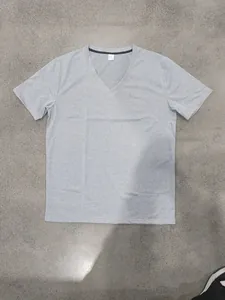 Vue à plat d'un t-shirt gris à col en V et manches courtes sur surface neutre
