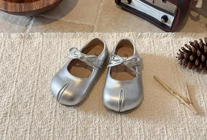 Close-up of silver Mary Jane shoes for girls with bow detail and metallic finish