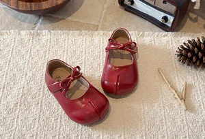 Detailed view of red Mary Jane princess shoes for girls with bow and soft leather finish