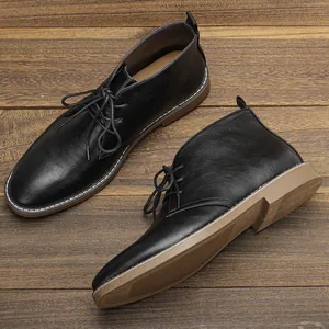 Detailweergave van zwarte heren chukka boots met het zijprofiel en de bruine zooltextuur