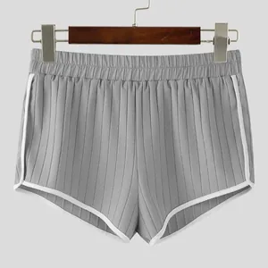 Macro view of grey ribbed athletic shorts with elastic waist and white piping detail