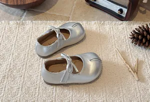 Detailed view of silver split-toe Mary Jane shoes for girls with cute bow decoration