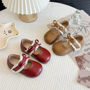 Mädchen Vintage Mary Jane Lederschuhe mit Spitzenbesatz und Schleifen in Rot und Braun.