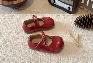 Top-down view of retro red split-toe Mary Jane shoes for girls with bow accent and soft sole