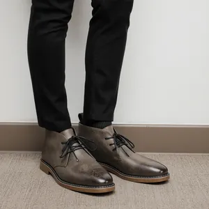 Detailopname van heren desert boots in getextureerd taupe met zwarte veters en stiksel