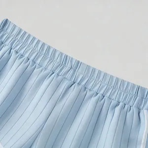 Close-up of pleated breathable fabric and elastic waist on men's blue shorts