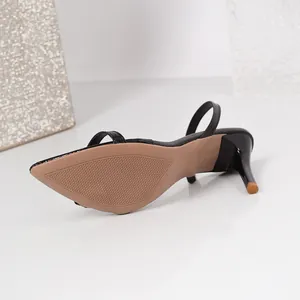 Close-up showing the textured sole and high stiletto heel of a black fashion sandal.