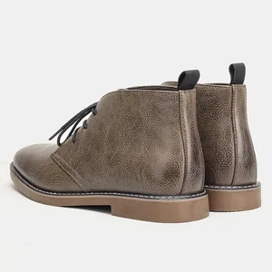 Gedetailleerd overzicht van het bruine getextureerde leer en de hiellus van desert boots.