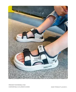 Nahaufnahme von weiß-schwarzen Sportsandalen für Kinder an den Füßen eines Modells im Freien.