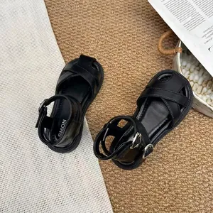 Top-down view of black girls' closed-toe sandals featuring cross straps and soft soles.