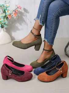 Detail van elegante suède pumps met blokhak en enkelbandjes in verschillende kleuren.