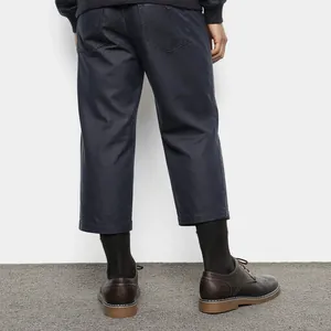 Vue arrière des chaussures Derby vintage en cuir marron pour hommes avec un pantalon bleu marine