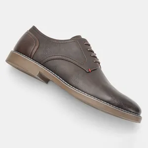 Vue latérale détaillée montrant la texture des chaussures de ville en cuir marron vintage