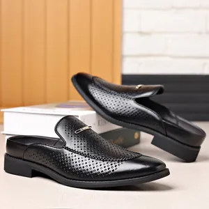 Detalle de primer plano de mules para hombre en cuero negro perforado con hebilla metálica dorada