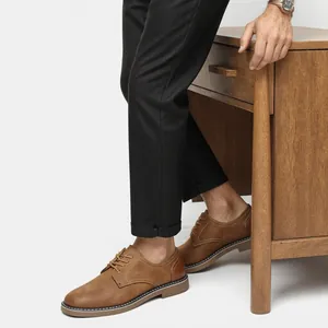 Vue latérale professionnelle de chaussures richelieu marron vintage avec un pantalon noir