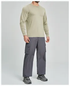 Full body shot of a man in an olive green long sleeve shirt and grey cargo pants