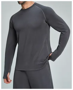 Dettaglio della maglia sportiva grigia da uomo con maniche raglan e asole per i pollici.