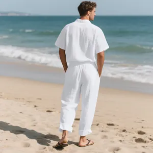 Back view of a man in a white linen beach set, showing short-sleeve shirt and long pants.