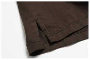 Macro detail of the side slit and precise stitching on a brown Merino wool blend shirt