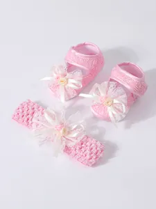 Detailansicht von rosa Spitzen-Babyschuhen und Stirnband-Set mit Blumenschleifen