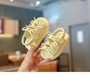 Gros plan détaillé de sandales jaunes pour bébé avec nœud décoratif et semelle souple