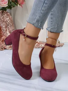 Elegante bordeauxrode suède pumps met ronde neus, stevige blokhak en een chic enkelbandje.