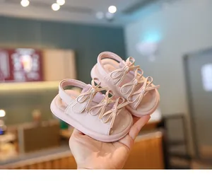 Vue détaillée des sandales roses pour bébé fille avec nœuds décoratifs et semelles souples.