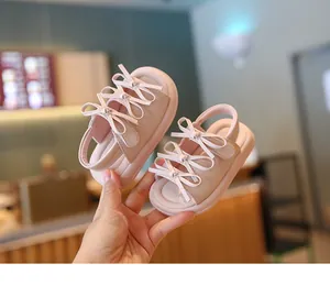 Gros plan de sandales roses pour bébé avec nœuds mignons et semelles souples antidérapantes