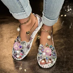 Detailed macro view of women's floral flat sandals featuring rhinestone flower decorations