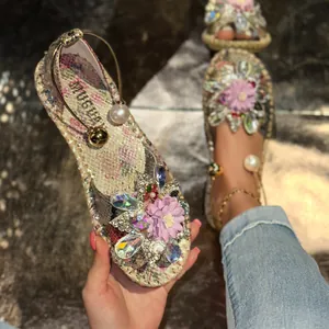 Close-up of floral flat sandals with colorful crystal beads and purple flower detail