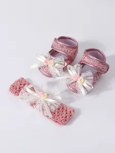 Detailansicht von rosa Spitzen-Babyschuhen und passendem Stirnband-Set für Neugeborene