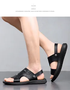 Nahaufnahme von schwarzen Leder-Sandalen für Herren am Fuß des Models vor grauem Hintergrund