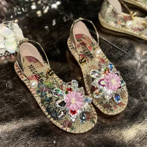Close-up of decorative floral and rhinestone embellishments on floral flat sandals