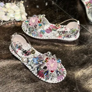 Detailed view of floral flat sandals with beaded flower and pearl strap