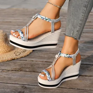 Détail de sandales compensées blanches pour femmes avec brides tressées argentées