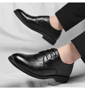 Gros plan sur des chaussures de ville noires pointues pour homme avec cuir perforé