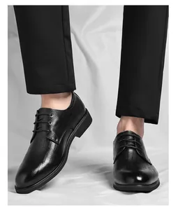 Détail de chaussures de ville pour hommes en cuir noir avec motif perforé et bout pointu