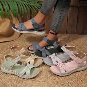Detailoverzicht van kleurrijke dames sandalen met geweven bandjes en klittenband.