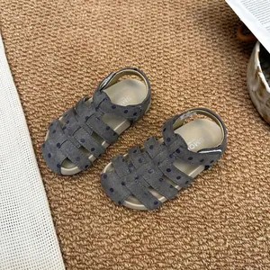 Draufsicht auf graue Mädchensandalen mit Polka Dots und Klettverschluss auf Matte